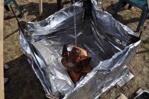 Checking in on the temperature of the Turkey. Notice the chunk of drywall at the base to buffer the lawn from burning. 